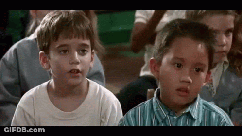 A Group Of Young Children Are Sitting In A Classroom And Looking At Something . GIF