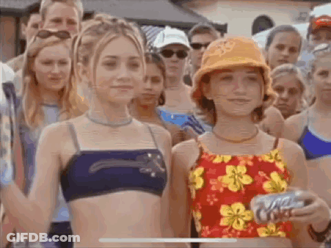 A Group Of Young Girls In Bikinis Are Standing Next To Each Other In Front Of A Crowd Of People . GIF