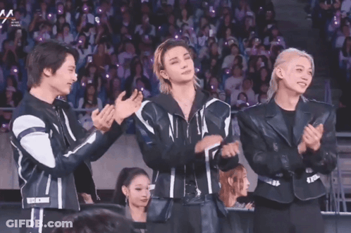 A Group Of Young Men Applauding In Front Of A Crowd With A Sign That Says Aa GIF