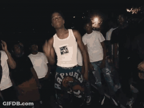 A Group Of Young Men Are Dancing And One Of Them Is Wearing A Raptors Shorts GIF