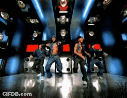 A Group Of Young Men Are Dancing In A Dark Room GIF