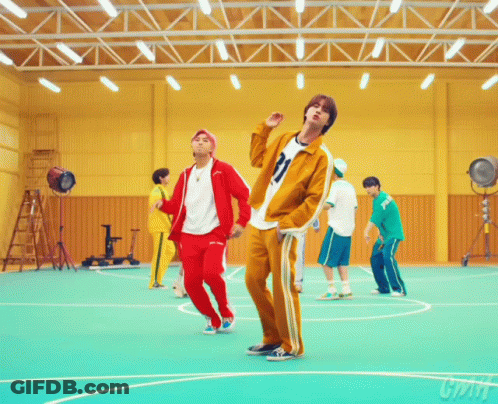 A Group Of Young Men Are Dancing In A Gym And One Of Them Has The Number 21 On His Jacket GIF