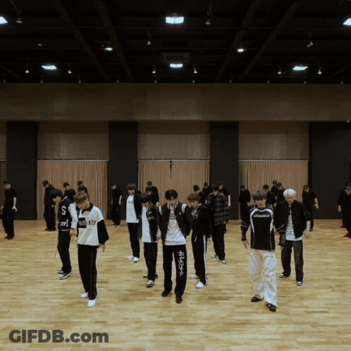 A Group Of Young Men Are Dancing In A Large Room And One Of Their Shirts Says ' Nc State ' On It GIF