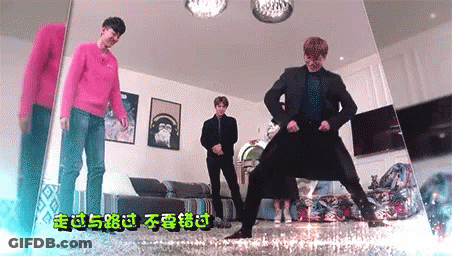 A Group Of Young Men Are Dancing In A Living Room With Chinese Writing On The Wall . GIF