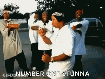 A Group Of Young Men Are Dancing In A Parking Lot And One Of Them Is Wearing A Bandana . GIF