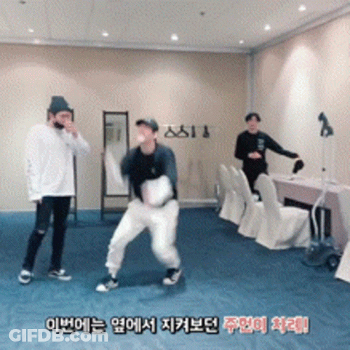 A Group Of Young Men Are Dancing In A Room With Foreign Writing On The Wall GIF