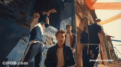 A Group Of Young Men Are Dancing In Front Of A Blue Wall And A Sign That Says @Maeuspitombeir GIF