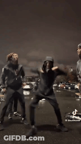A Group Of Young Men Are Dancing In Front Of A Car In A Tik Tok Video . GIF