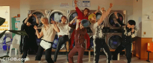 A Group Of Young Men Are Dancing In Front Of A Laundromat With Numbers 1 2 And 3 On Them GIF