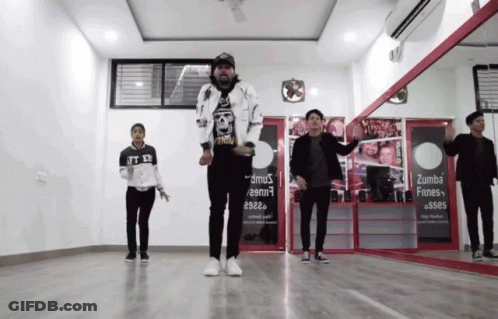 A Group Of Young Men Are Dancing In Front Of A Sign That Says Zumba Fines GIF