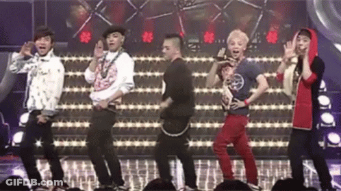 A Group Of Young Men Are Dancing On A Stage In Front Of A Crowd Of People . GIF