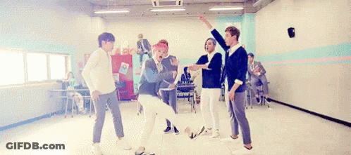A Group Of Young Men Are Dancing Together In A Room In A School . GIF