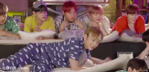 A Group Of Young Men Are Laying On Their Stomachs On The Floor . GIF