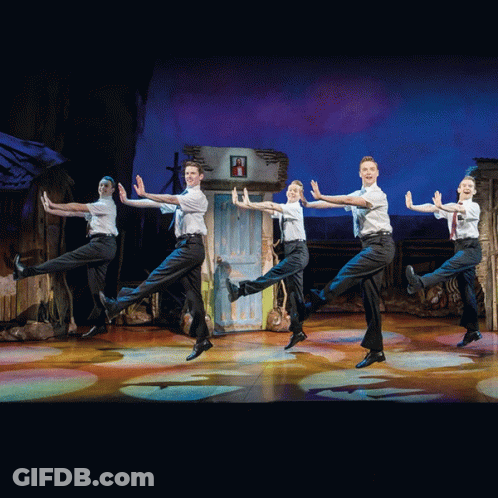 A Group Of Young Men Are Performing On A Stage GIF