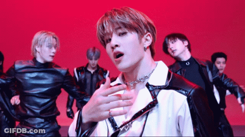 A Group Of Young Men Are Performing On A Stage With A Red Background GIF