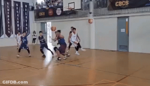 A Group Of Young Men Are Playing A Game Of Basketball On A Court . GIF