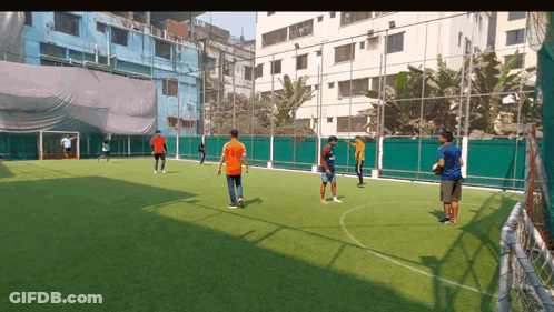 A Group Of Young Men Are Playing Soccer On A Field GIF