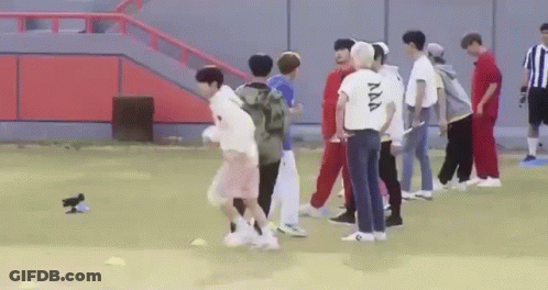 A Group Of Young Men Are Playing Soccer On A Field With A Bird . GIF