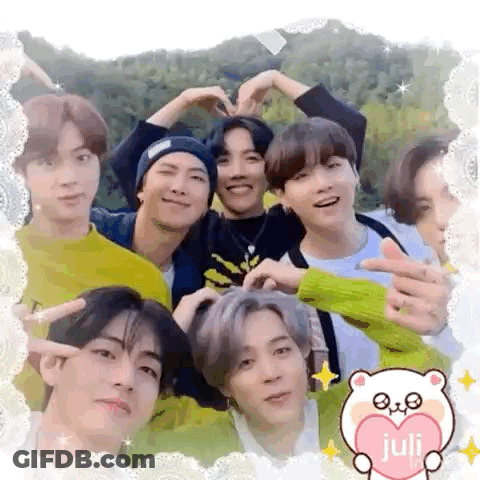 A Group Of Young Men Are Posing For A Picture And Making A Heart With Their Hands . GIF