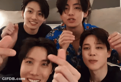 A Group Of Young Men Are Posing For A Picture And Making Heart Shapes With Their Fingers . GIF