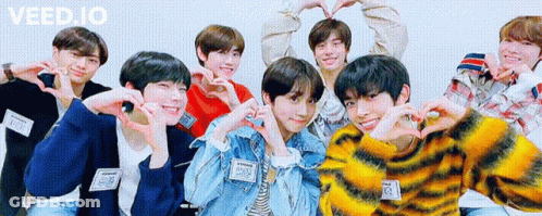 A Group Of Young Men Are Posing For A Picture And Making Hearts With Their Hands . GIF