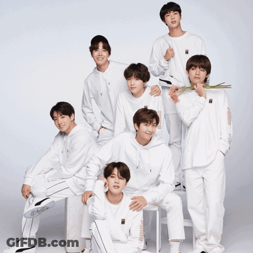 A Group Of Young Men Are Posing For A Picture And One Of Them Is Holding A Flower GIF