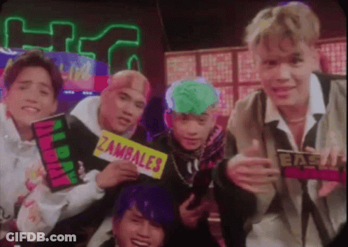 A Group Of Young Men Are Posing For A Picture And One Of Them Is Holding A Sign That Says Zambale . GIF