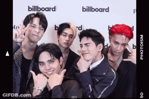 A Group Of Young Men Are Posing For A Picture In Front Of A Billboard Sign GIF