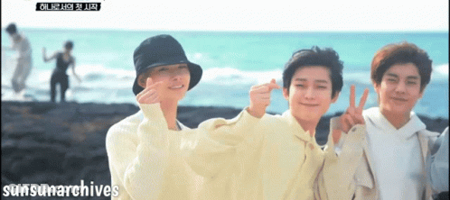 A Group Of Young Men Are Posing For A Picture On A Beach With Sunsunarchives Written On The Bottom Right GIF