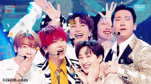 A Group Of Young Men Are Posing For A Picture On A Stage . GIF
