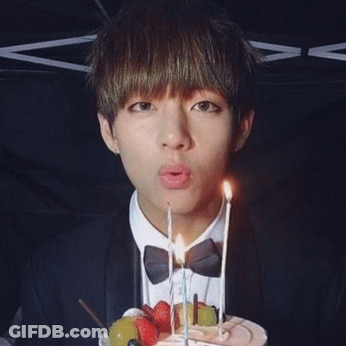 A Group Of Young Men Are Posing For A Picture With A Cake . GIF