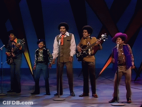 A Group Of Young Men Are Singing Into Microphones And Playing Guitars GIF