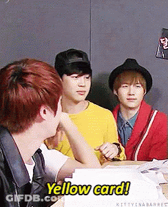 A Group Of Young Men Are Sitting At A Table And One Of Them Says Yellow Card GIF