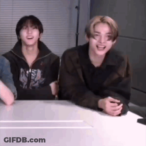 A Group Of Young Men Are Sitting At A Table Laughing And Smiling . GIF