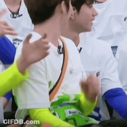 A Group Of Young Men Are Sitting In A Stadium And Applauding Each Other . GIF