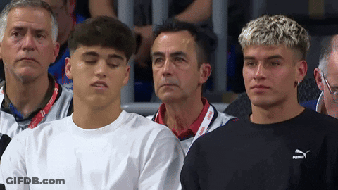 A Group Of Young Men Are Sitting In A Stadium And One Of Them Is Wearing A Puma Sweatshirt GIF