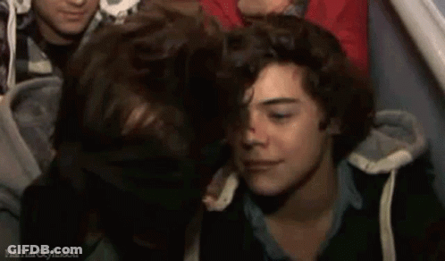 A Group Of Young Men Are Sitting Next To Each Other In A Crowd . GIF