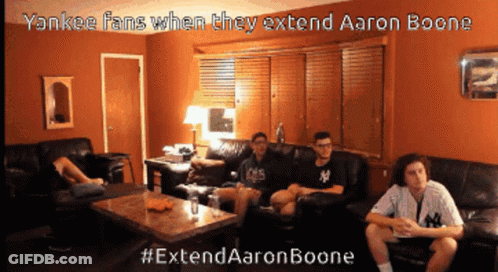 A Group Of Young Men Are Sitting On A Couch In A Living Room Watching A Baseball Game GIF