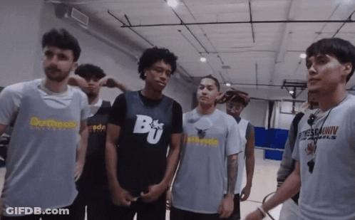 A Group Of Young Men Are Standing In A Gym With One Wearing A Shirt That Says Brother GIF
