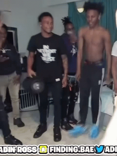 A Group Of Young Men Are Standing In A Room With A Sign That Says ' Finding Bae ' GIF