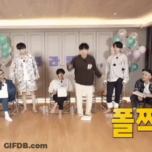 A Group Of Young Men Are Standing In A Room With Balloons And Bottles . GIF