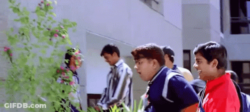 A Group Of Young Men Are Standing In Front Of A Building And Talking To Each Other . GIF