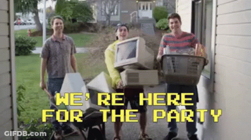 A Group Of Young Men Are Standing In Front Of A House Holding A Computer And A Basket Of Groceries . GIF