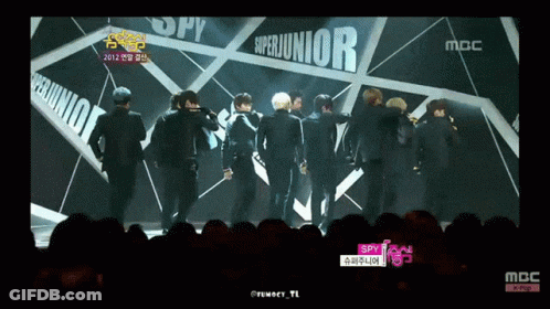 A Group Of Young Men Are Standing In Front Of A Sign That Says Superjunior GIF