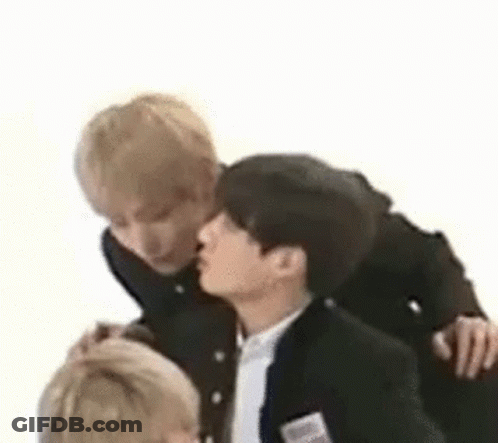 A Group Of Young Men Are Standing Next To Each Other And Kissing Each Other . GIF