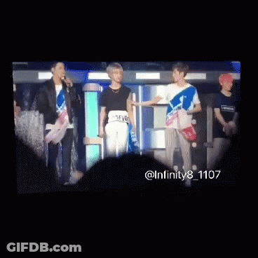 A Group Of Young Men Are Standing Next To Each Other And Looking At Each Other . GIF