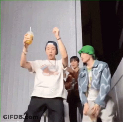 A Group Of Young Men Are Standing Next To Each Other And One Is Holding A Drink In His Hand . GIF