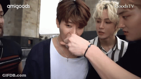 A Group Of Young Men Are Standing Next To Each Other And One Of Them Is Touching Another Man 'S Nose GIF