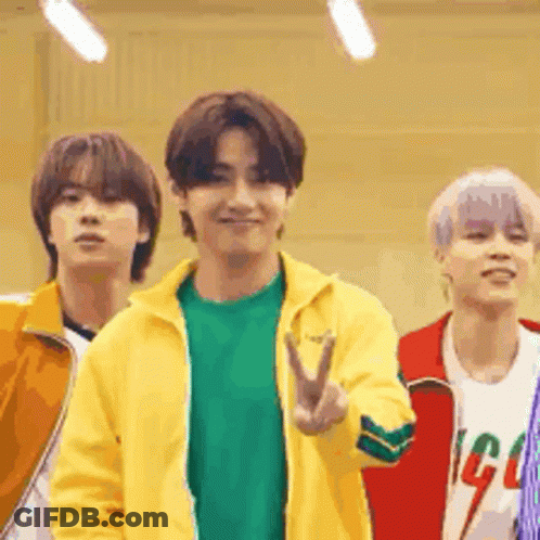 A Group Of Young Men Are Standing Next To Each Other Giving The Peace Sign . GIF