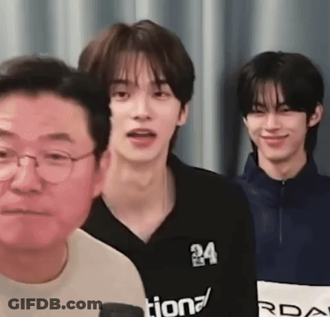 A Group Of Young Men Are Standing Next To Each Other . GIF